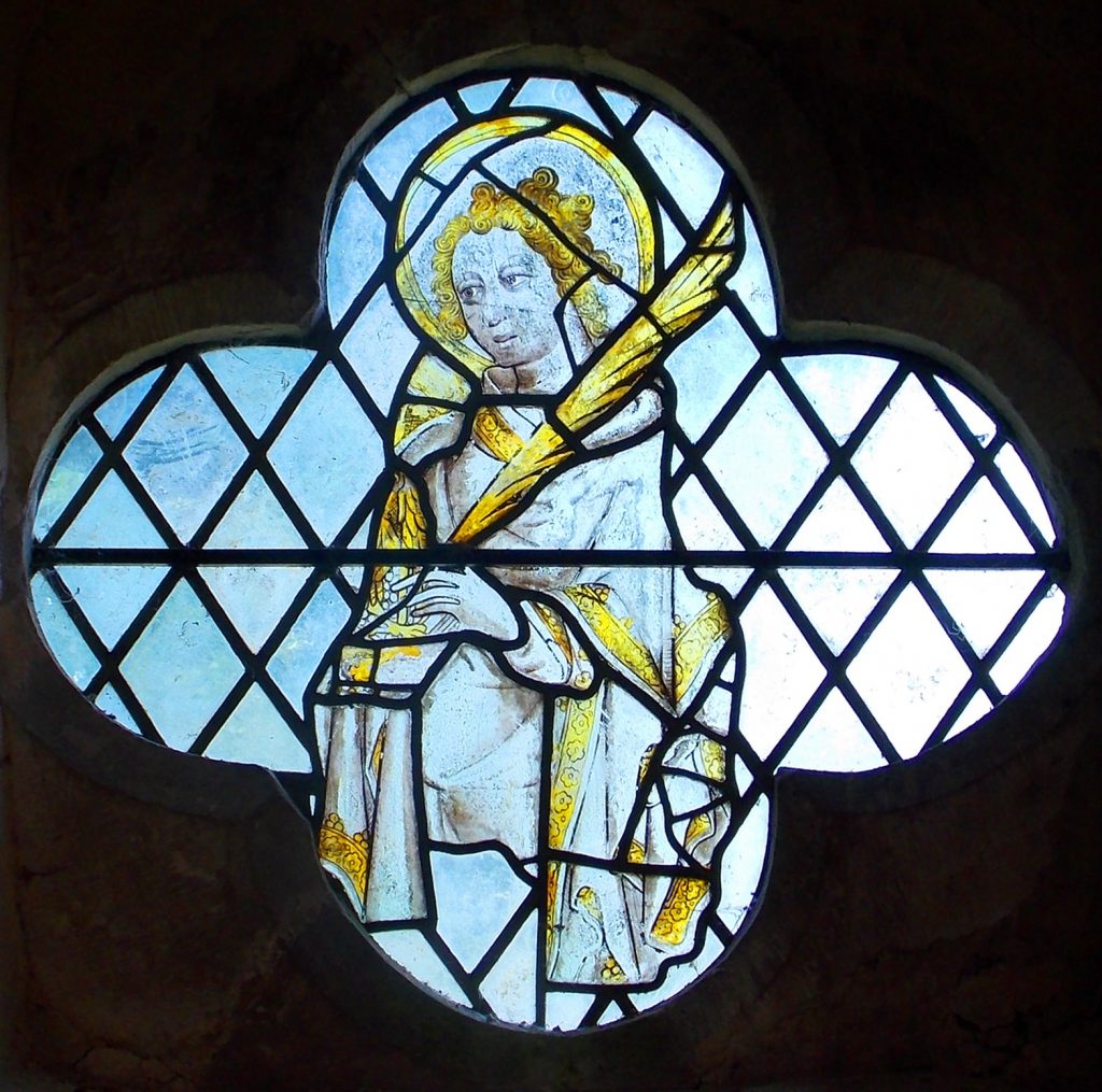 Three photos of medieval stained glass in the windows on the north aisle wall